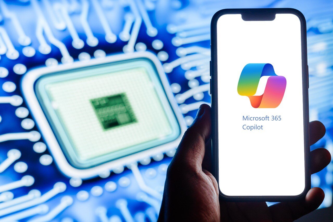 Smartphone displaying the Microsoft 365 Copilot logo and text, with a computer chip in the background.
