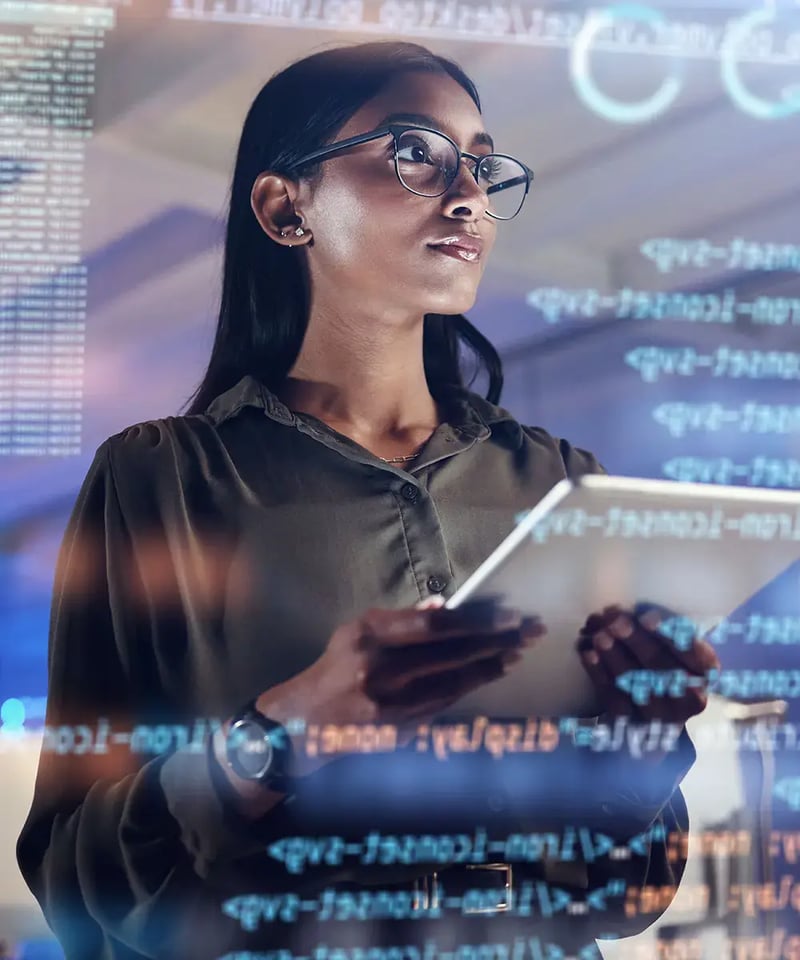 An IT professional on a tablet and software, coding a hologram.