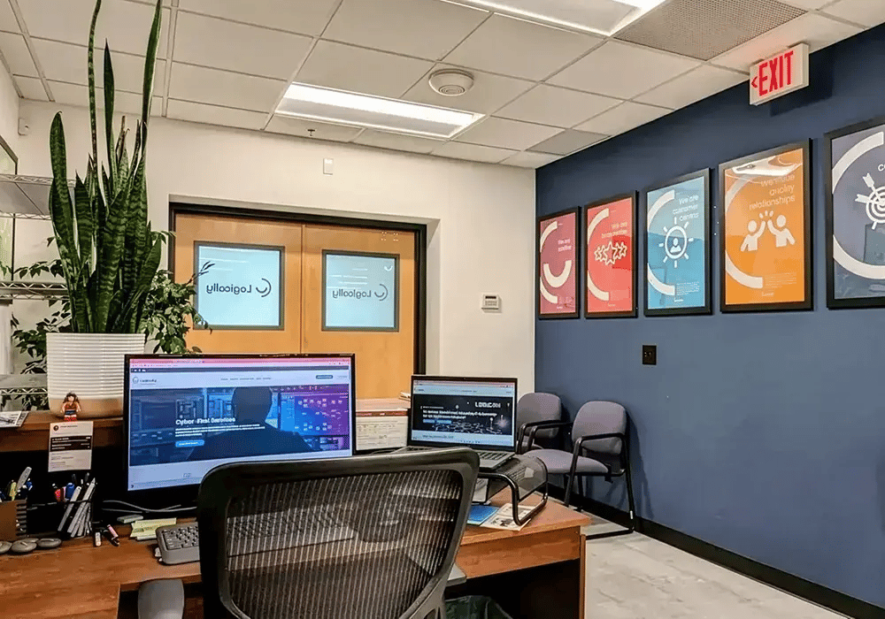 Modern office with a desk featuring two monitors displaying a website.