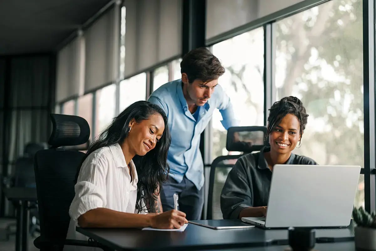 Three colleagues collaborate in a modern office.