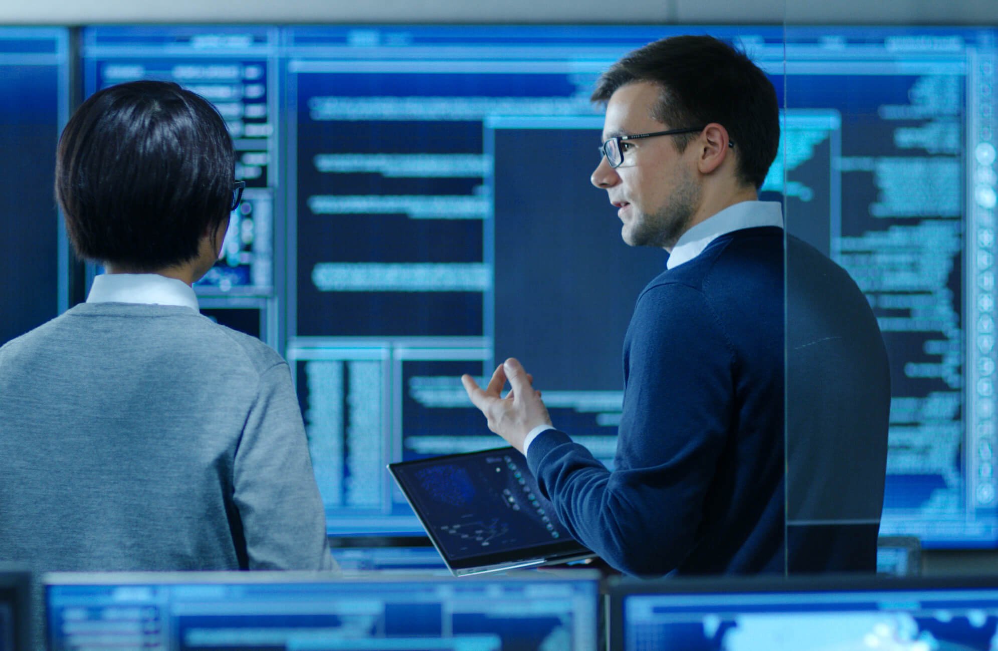 Two men reviewing data on a big computer