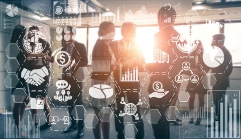 Professionals discussing business strategies in a sunlit office, with transparent overlays of charts and graphs representing data analytics